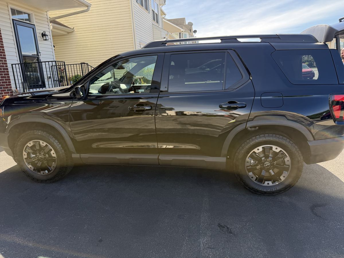 Side profile of the black Honda Passport after detailing, reflective paint and clean glass