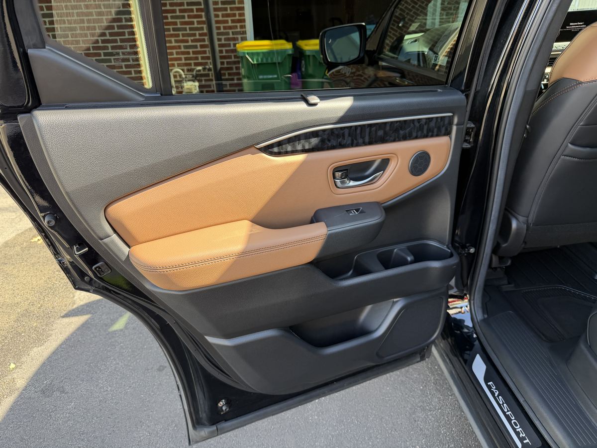 Honda Passport rear door panel after detailing, conditioned tan leather and clean door pocket