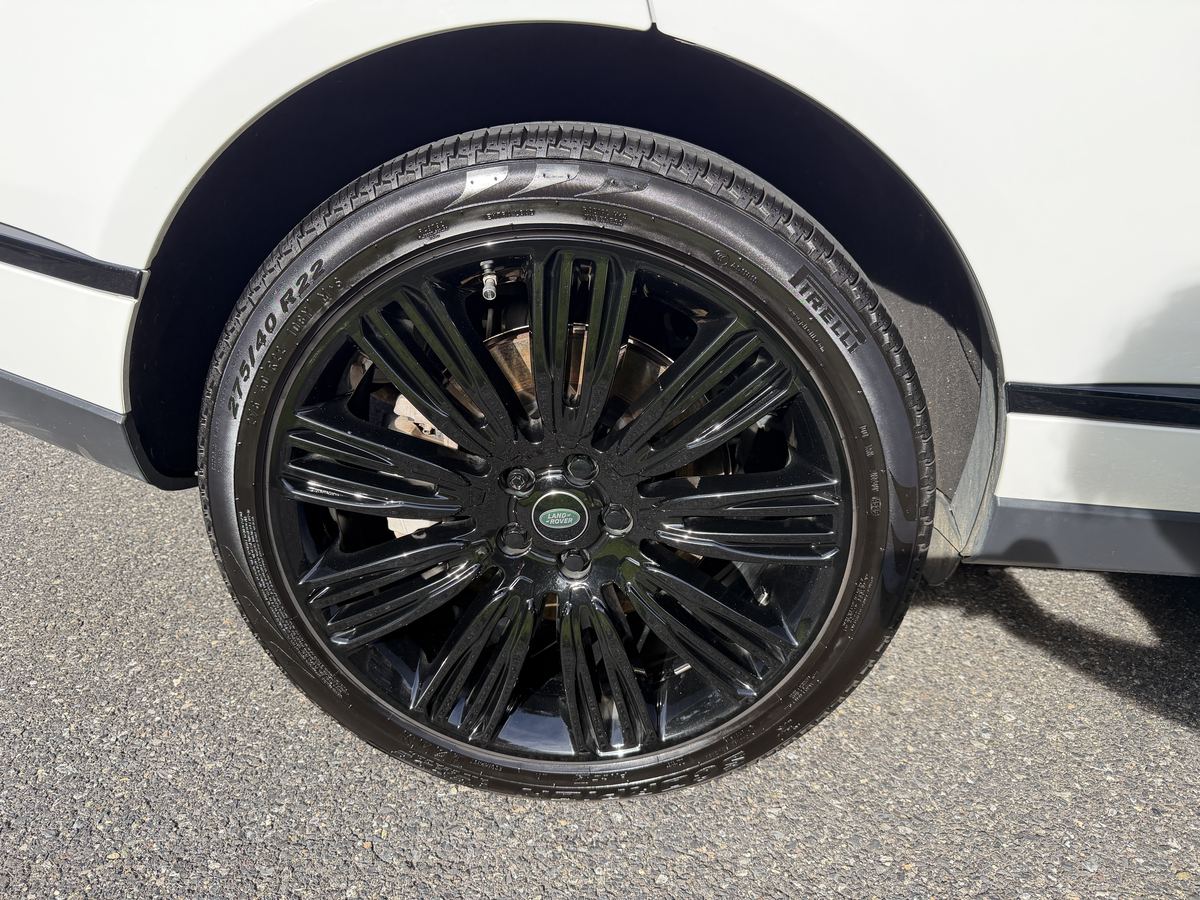 Close-up of a gloss black Range Rover wheel and dressed tire after wheel and tire cleaning